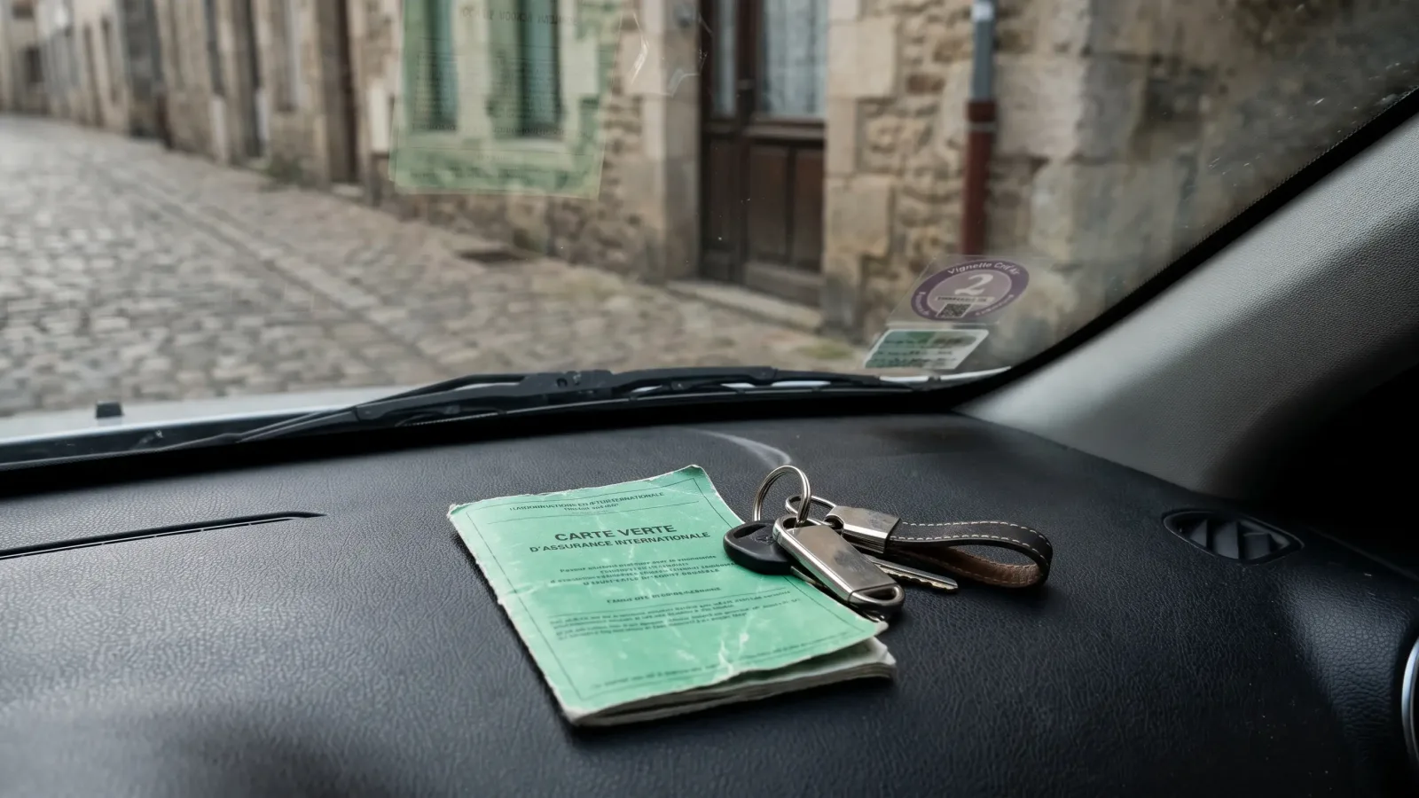 Carte internationale d'assurance et clés de voiture sur le tableau de bord